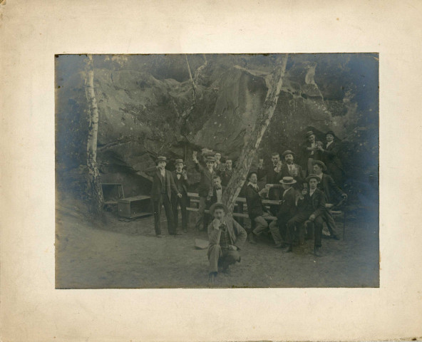 [Groupe de jeunes hommes dans une clairière portant un toast et posant sur des rochers. Patronage chrétien ?]