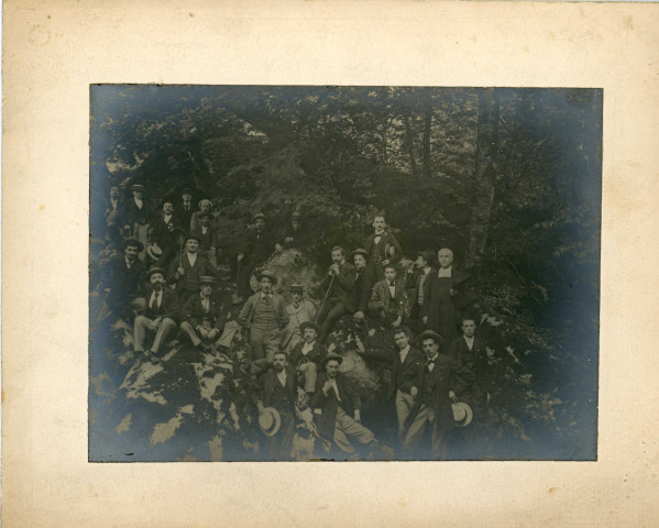 [Groupe de jeunes hommes dans une clairière portant un toast et posant sur des rochers. Patronage chrétien ?]