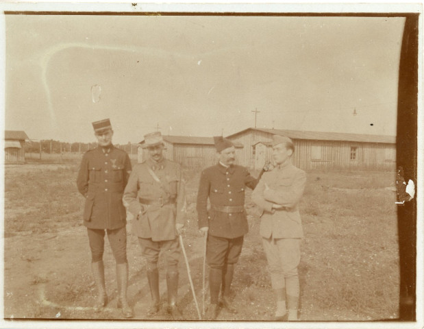 [Photographie de quatre officiers devant les baraquements. Troisième en partant de la gauche : Jules Zirnheld]